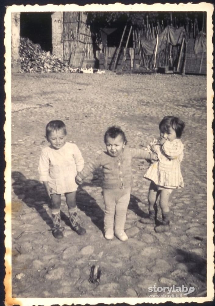 Tre bambini nell'aia